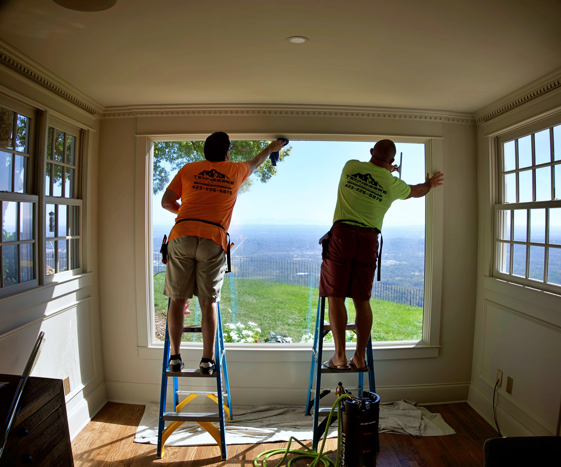 Workers tinting large residential window